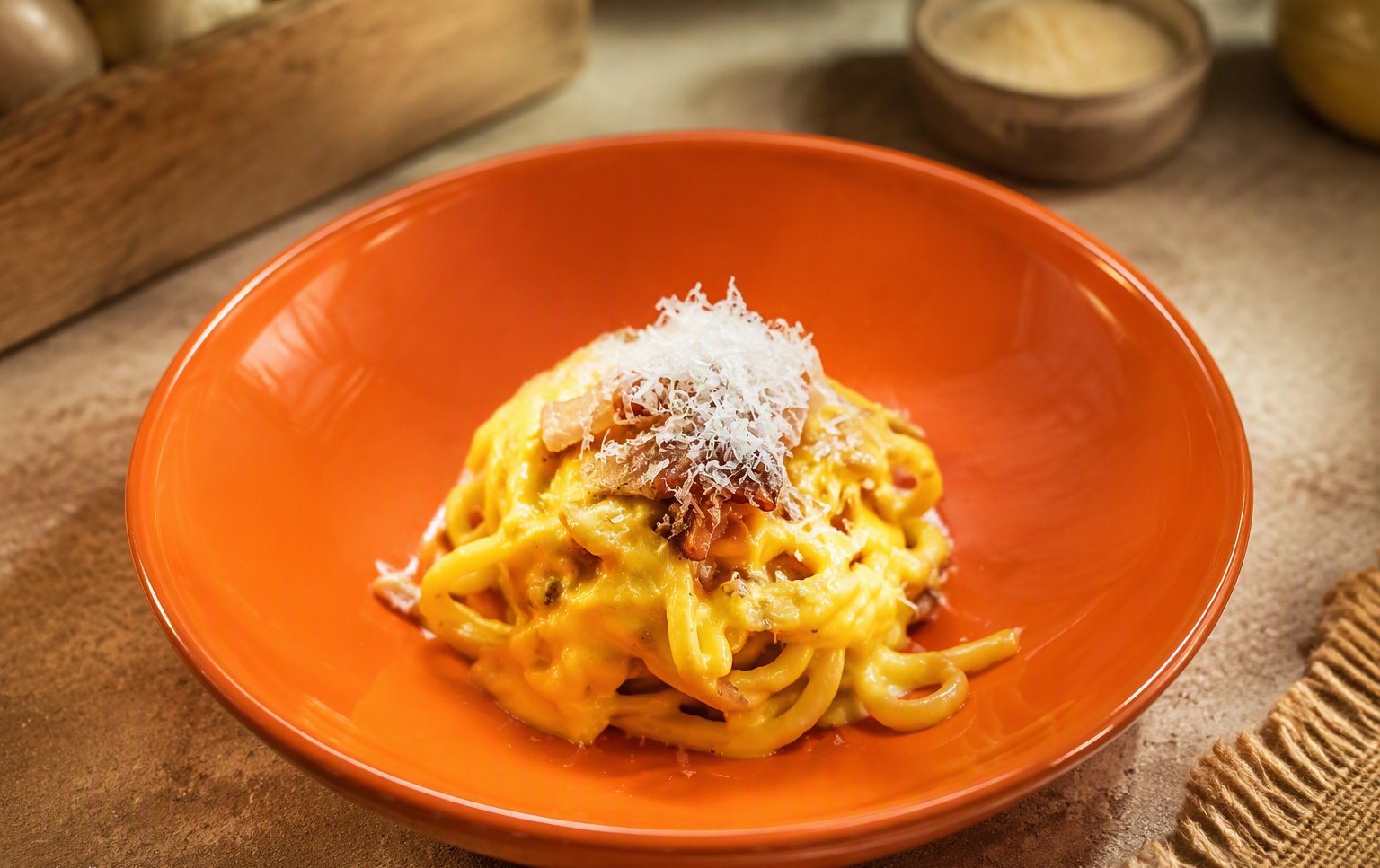 Le tagliatelle al ragù con parmigiano sul piatto arancione